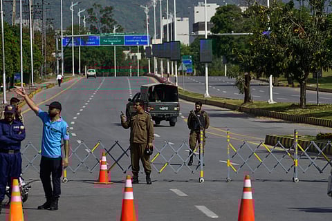 Police officers stand guard at a checkpoint ahead of the second round of negotiations between the U.S. and Iran, in Islamabad, Pakistan.