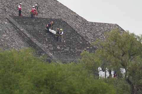 Forensic workers carry the body of a victim down a pyramid after authorities said a gunman opened fire, in Teotihuacan, Mexico, Monday, April 20, 2026.