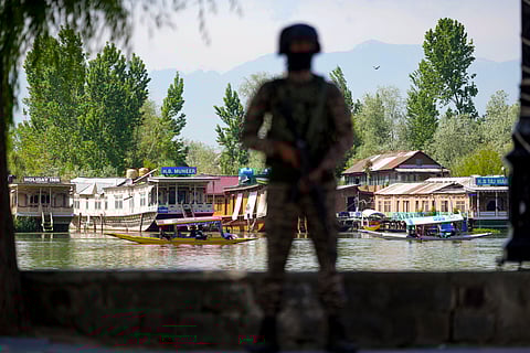 A security official keeps vigil along the Dal Lake area amid heightened security ahead of the Pahalgam attack anniversary, in Srinagar, Tuesday, April 21, 2026.