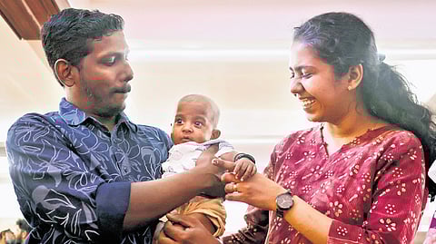 Sherin Ann John and Arun Abraham with eight‑month‑old Dhriya, who received Aalin’s liver, at a meeting organised by KIMSHEALTH in Thiruvananthapuram on Wednesday.