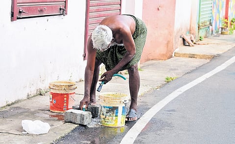 An elderly man repairing a broken pipe in Mattancherry.