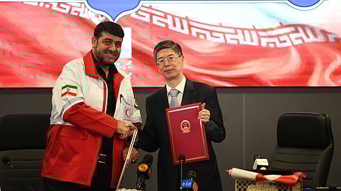 In this photo released by Xinhua News Agency, Chinese Ambassador to Iran Cong Peiwu, right and Iranian Red Crescent Society (IRCS) President Pirhossein Kolivand attend a signing ceremony for the handover certificates of China's emergency humanitarian assistance to Iran in Tehran, Iran, April 15, 2026.