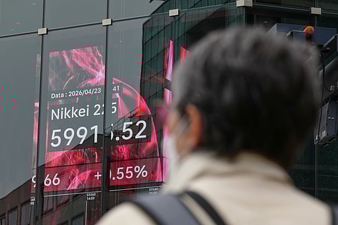A person stands in front of an electronic stock board showing Japan's Nikkei index at a securities firm Thursday, April 23, 2026, in Tokyo.
