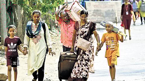 With no bus services available at the Karimnagar bus stand, a family returns home walking on Wednesday.