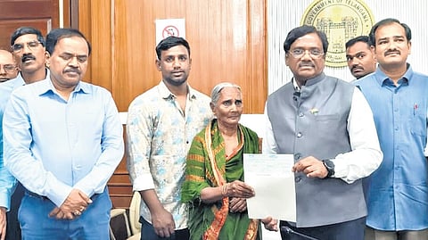 Labour Minister Vivek Venkatswamy hands over a cheque to the kin of a deceased gig worker at his chamber in the Secretariat on Wednesday.
