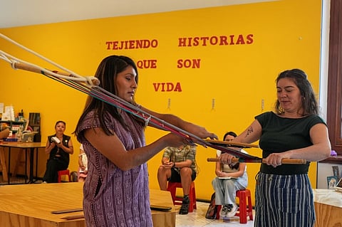Muxe artist Xaneri Merino, left, gives a backstrap loom workshop for LGBTQ+ people in Mexico City, Tuesday, April 14, 2026.