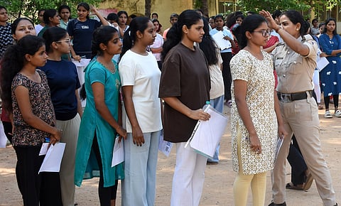 Police staff check Students with metal detectors before entering examination hall to appear for CET exam Mysuru on Thursday.