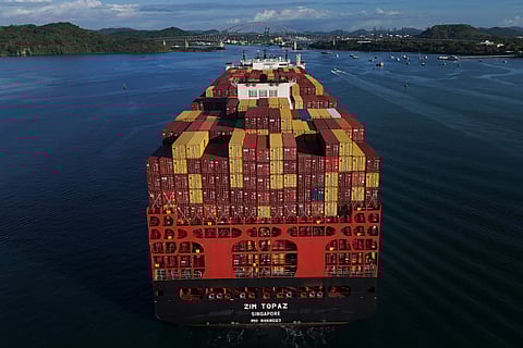 Cargo containers are stacked on a cargo ship moving through the Panama Canal, at sunrise in Panama City, Wednesday, March 25, 2026.