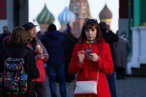 A woman holding her smartphone leaves Red Square in Moscow, March 11, 2026.