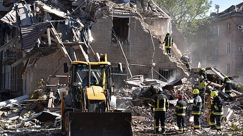 Rescue workers clear the rubble of a residential building destroyed by a Russian strike on Dnipro, Ukraine, Saturday, April 25, 2026.