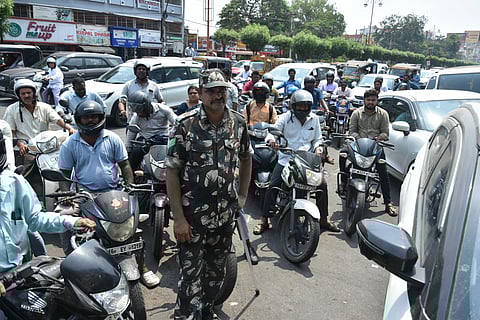 Police personnel stand guard at petrol bunks as commuters throng to fill fuel in Vijayawada on Monday.