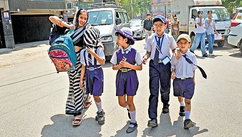 A young girl wraps her mother’s saree around her face to shield herself from the scorching sun while returning from school on Tuesday | Sayantan Ghosh