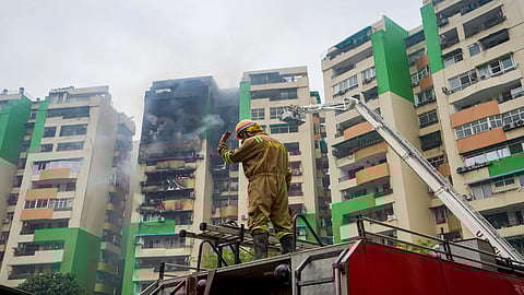 A firefighter douses a fire that broke out in Green Avenue Society, Indirapuram, Ghaziabad, Wednesday, April 29, 2026.