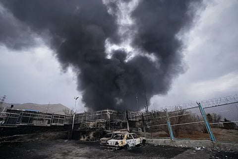 A thick plume of smoke rises from an oil storage facility hit by a U.S.-Israeli strike in Tehran, Iran, March 8, 2026.