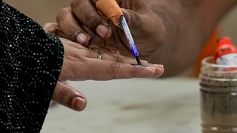 A polling official marks a voter's finger with indelible ink during the second and final phase of the West Bengal Assembly elections, at a polling station in Kolkata, Wednesday, April 29, 2026.