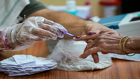 A polling official marks a voter's finger with indelible ink during the second and final phase of the West Bengal Assembly elections, at a polling station in Kolkata, Wednesday, April 29, 2026.