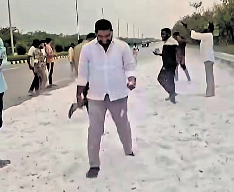 People play with iceballs after a hailstorm on the ORR stretch on Monday evening