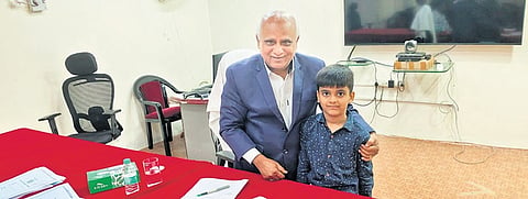 State Information Commissioner Sri Deshala Bhupal congratulates 8-year-old Kannekanti Karthik for his RTI query and for following it up, in Nalgonda on Wednesday