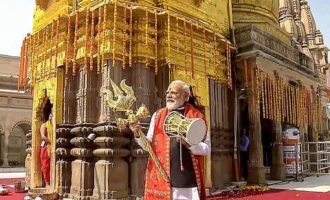 Prime Minister Narendra Modi holds a trident and a 'damru' (small hand drum) at Kashi Vishwanath Temple during his two-day visit to Uttar Pradesh, in Varanasi.