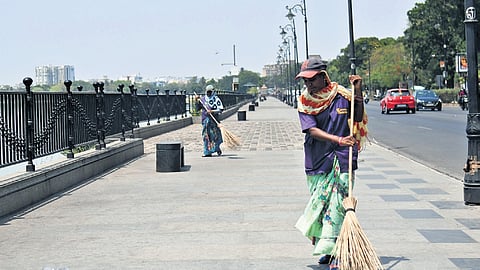 Sanitation workers use scarves and caps to shield themselves from the summer heat while working at Tank Bund in Hyderabad on Thursday