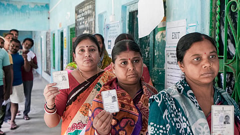 Voters show their identity cards as they wait in a queue to cast their votes at a polling station during a repoll ordered by the Election Commission in South 24 Parganas district.