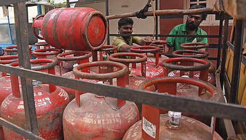 Workers unload LPG Cylinders off a light commercial vehicle in Bengaluru.