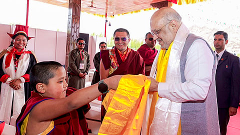 Union Home Minister Amit Shah interacts with a novice monk during the inauguration of the first international exposition of holy relics of Lord Buddha on the occasion of Buddh Purnima in Ladakh, May 1, 2026.