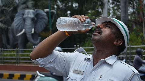 A police officer quenches his thirst as he discharges his duties on a sunny afternoon in Vijayawada.