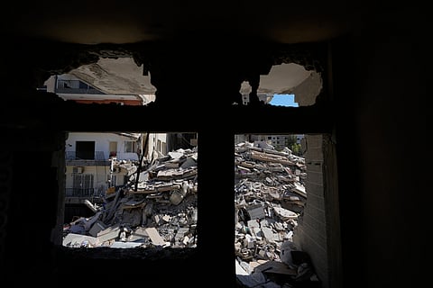 A destroyed building that was hit few weeks ago by an Israeli airstrike is seen through a damaged house in the southern port city of Tyre, Lebanon, Thursday, April 30, 2026.
