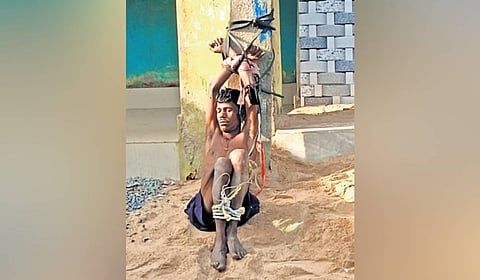 Bibhuti Naik tied up to a pole by locals after he assaulted his father.
