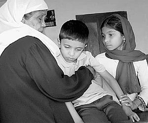 Shahal and her elder sister along with their grandmother Fathima in front of the residence of Abdul Kabeer in Chemmankadavu near Malappuram on Friday.