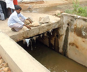 Death trap: A local points to the nala at Venkateshanagar into which Ramesh Kumar had stepped during the heavy rain in Hyderabad on Monday night.