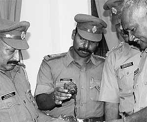 Superintendent of Police Sivadasan (R) and other police personnel inspect the country bombs seized at Keezh Puthupet in Puducherry on Monday