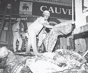 Firemen at the spot of the fire accident in Cauvery Emporium on M G Road on Tuesday.