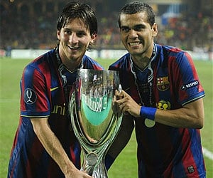 Barcelona's Lionel Messi from Argentina, left, and his teammate Daniel Alves, from Brazil, hold the UEFA Super Cup trophy. (Photo: AP)