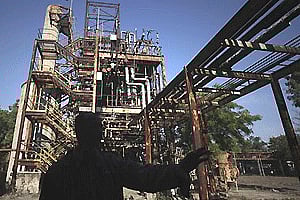 A security guard is silhouetted against defunct machinery at the Union Carbide pesticide plant in Bhopal. AP
