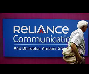 A man walks past a logo of Reliance Communication before the Annual General Meeting in Mumbai in this September 2009 (File photo/Reuters)
