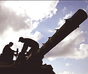 Israeli soldiers stand on top of a tank at a staging area on the Israel-Gaza border. (Photo: AP)