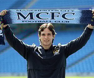 Manchester City's new signing, Paraguayan soccer player, Roque Santa Cruz holds up a team scarf during a photo call. (Photo: AP)
