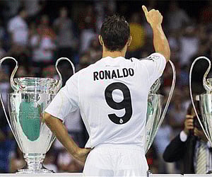 Real Madrid new soccer player Cristiano Ronaldo poses next to the club's trophies during his presentation at the Santiago Bernabeu stadiu. (Photo: AP)