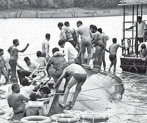Rescuers carrying out their task at the mishap site in the Thekkady lake. Seen sunk is `Jalakanyaka’, the double-decker passenger boat of the KTDC.