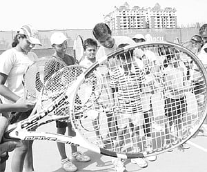 Vasudeva Reddy (left) and S Narendra Nath train children at NVK Tennis Academy.