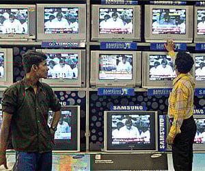 An salesman tunes televisions at an electronic consumer product shop in Kolkata. (Photo: Reuters)