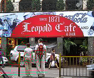 A couple of tourists in front of the Leopold Cafe in Mumbai. (Image reproduced as per the Wikimedia Commons license)