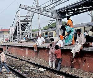 Passengers negotiate the rail track at Vyasarpadi Jiva station; and (inset) the debris of the recent train collision on the platform.