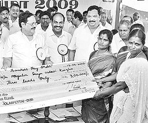 PWD Minister Duraimurugan giving away a cheque for Rs 3 lakh to a beneficiary of the Roja Magalir Suya Udavi Kuzhu during the Yelagiri Summer Festival
