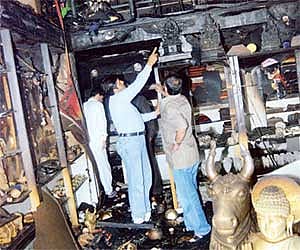 Officials inspecting Cauvery Industries Exhibits which was gutted in a fire mishap, at Trinity Circle.