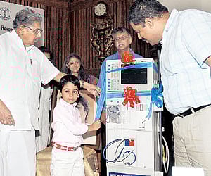 Union minister Vayalar Ravi helping his grandson Varun Krishna to inaugurate the new dialysis unit, in the city on Saturday.