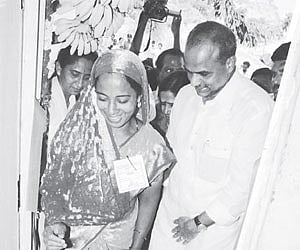 Shaik Maimun is all smiles as she takes the first step into her new house accompanied by CM Y S Rajasekhara Reddy at Ithepalle in Chittoor.