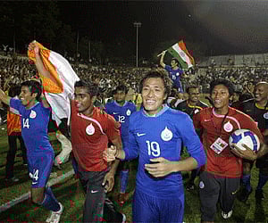 Indian captain Baichung Bhutia, background center, and team mates celebrate with the Indian national flag after the final of the Nehru Cup. (Photo:AP)